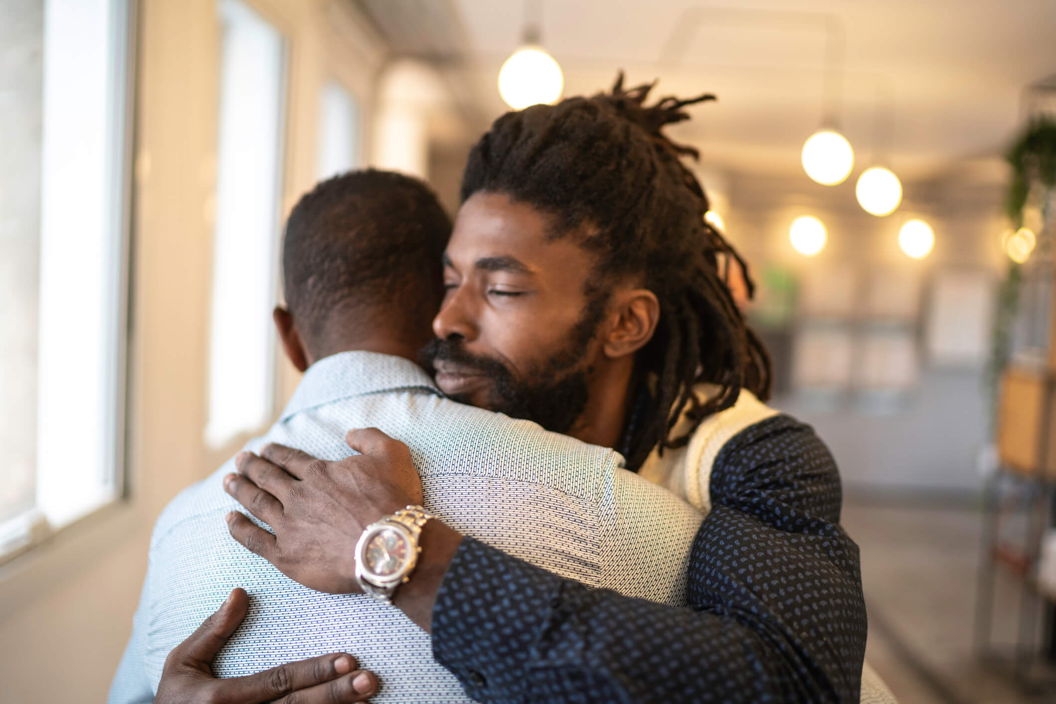 Two men hug after a meeting for a 12-step recovery group.
