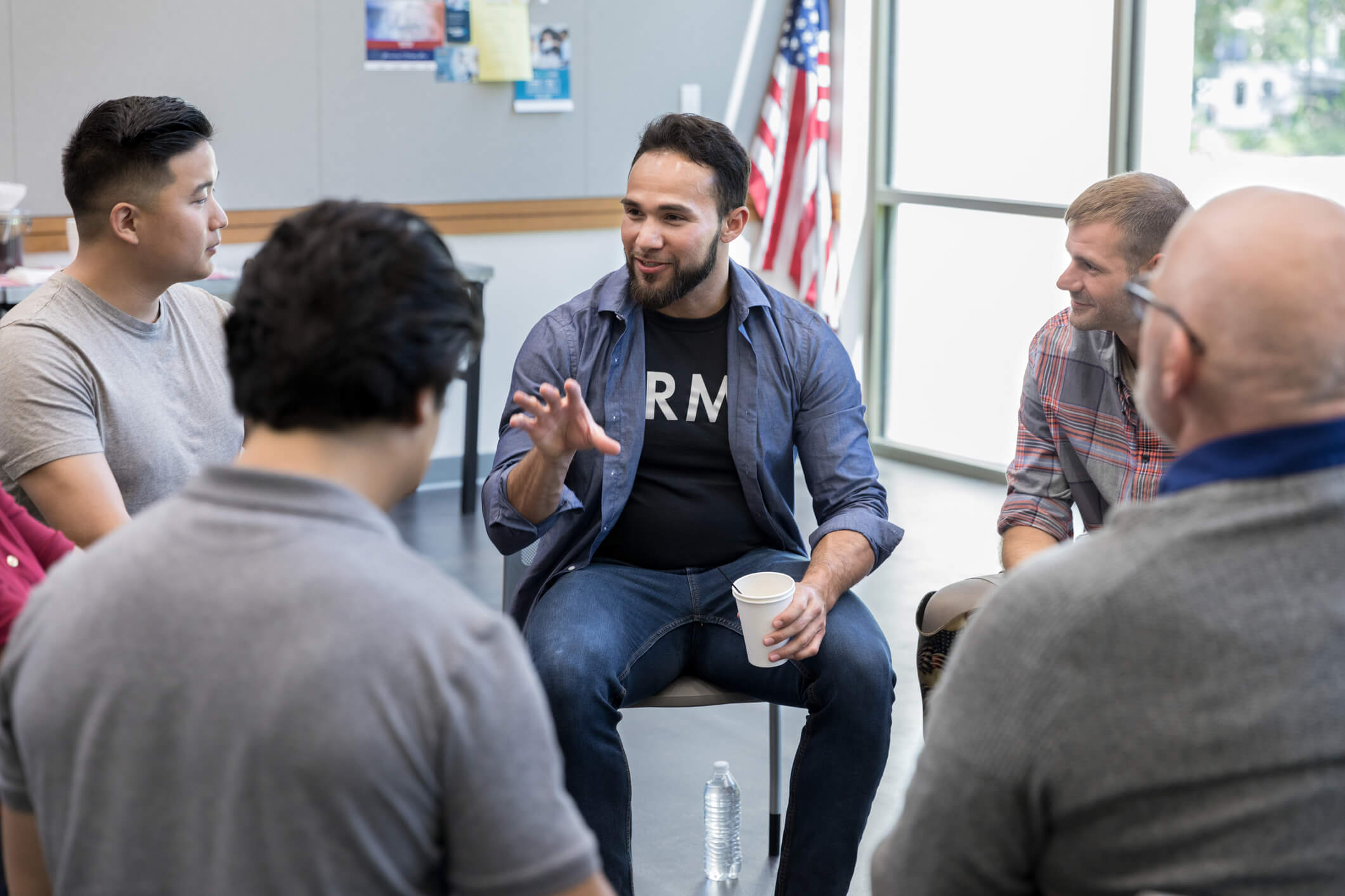 A young man speaks to like-minded individuals in a support group.